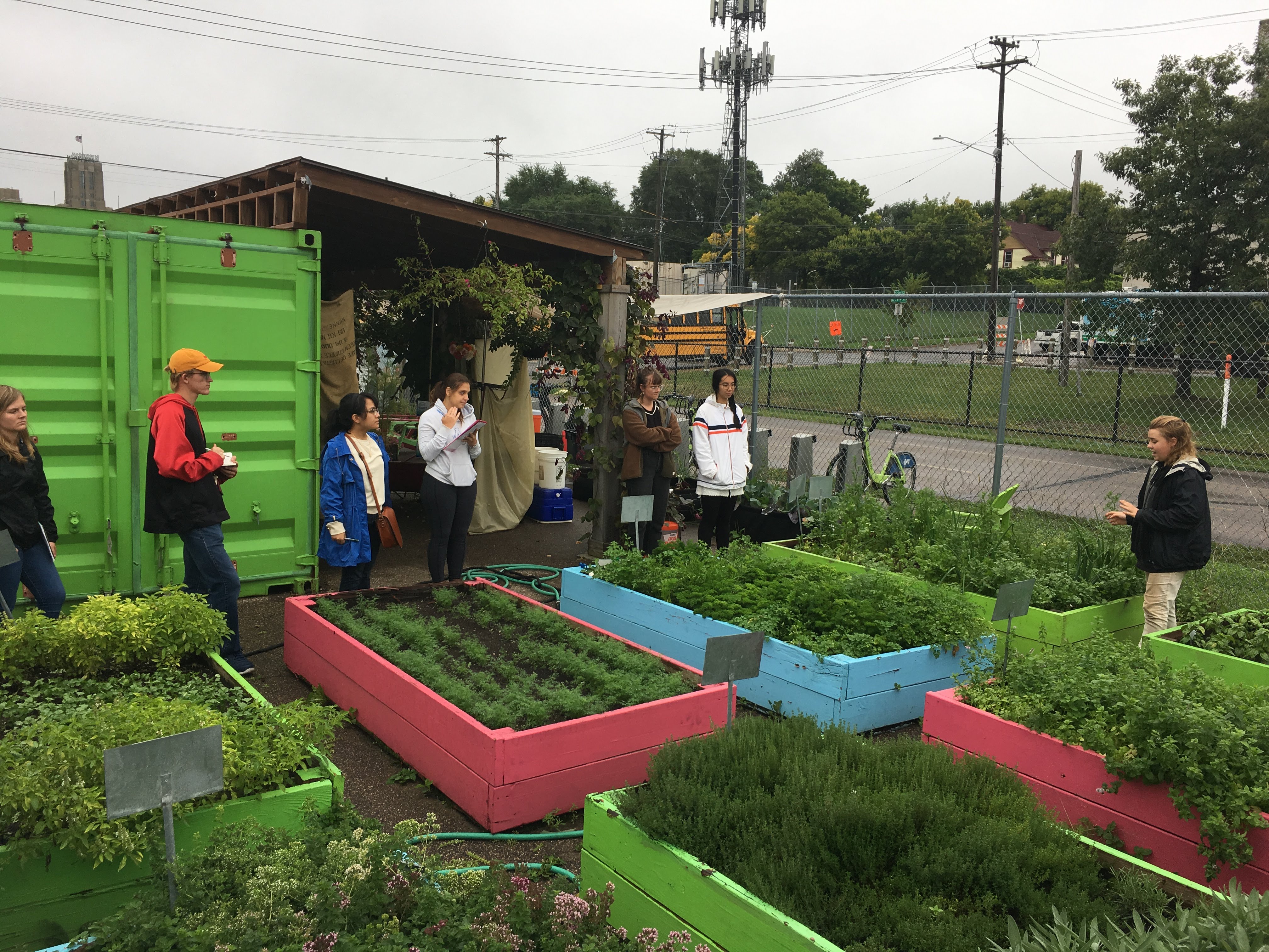 students learning from an instructor in an urban garden outside