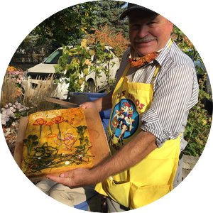 Professor Neil Anderson standing in a garden holding a baked loaf of focaccia. 